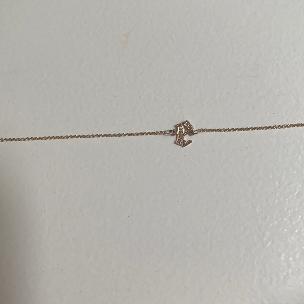 M jewelers 14 kt gold and Diamond gothic lowercase e.